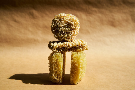 Creative food composition of instant ramen noodles over beige.