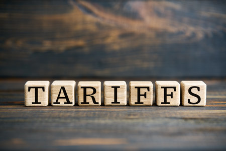 Word TARIFFS on wooden blocks over rustic wooden background. Economic trade, finance concept.の写真素材