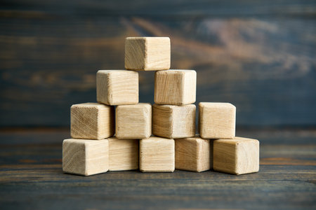 Collapsing pyramid of natural wooden cubes, The concept of destruction and instability.の写真素材