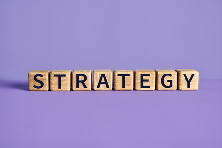 Wooden blocks spelling the word STRATEGY on purple background. business cocnept