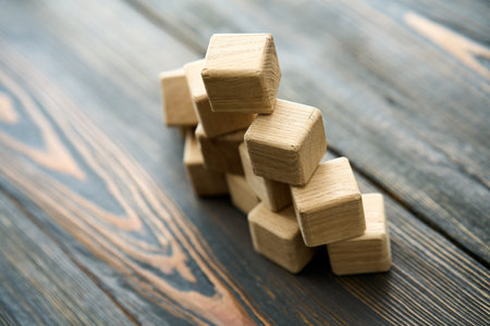 Collapsing pyramid of natural wooden cubes. The concept of destruction and instability.の写真素材