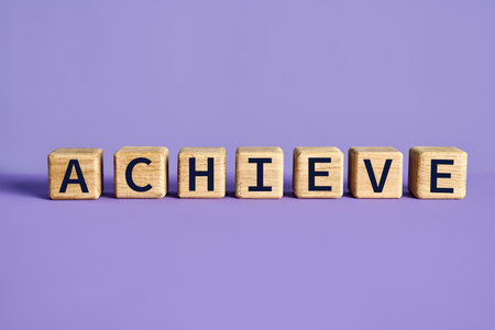Achieve word on wooden cubes blocks over purple background. Motivation conceptの写真素材