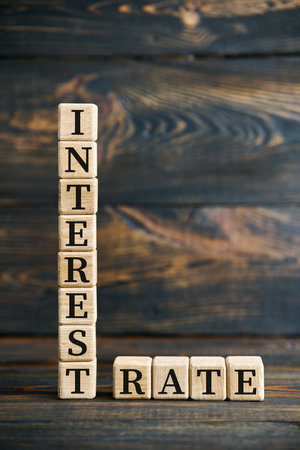 The word INTEREST RATE on wooden cubes vertically and horizontally over dark rustic backgroundの写真素材