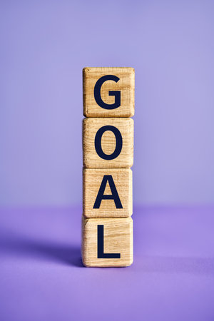 The word GOAL on wooden blocks over vibrant purple background. Motivation conceptの写真素材