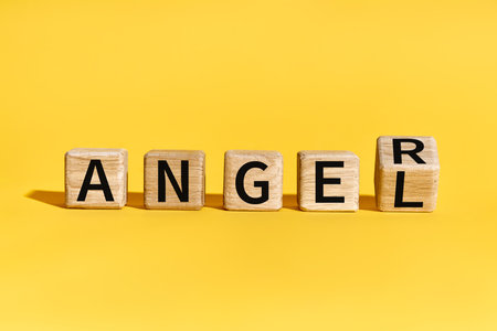 Wooden blocks forming words ANGEL to ANGER over yellow background. Emotions conceptの写真素材