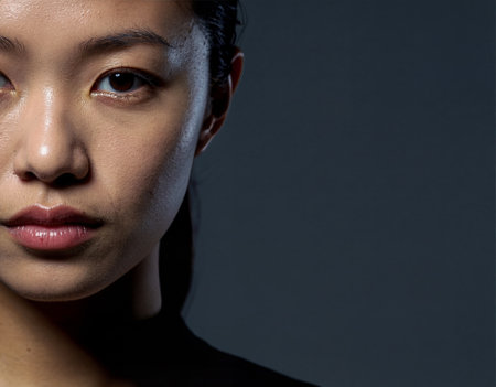Young Asian female face with wet skin and water droplets showing texture on dark background. Generative AIの素材