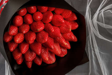 bouquet of strawberries in a black wrapperの写真素材