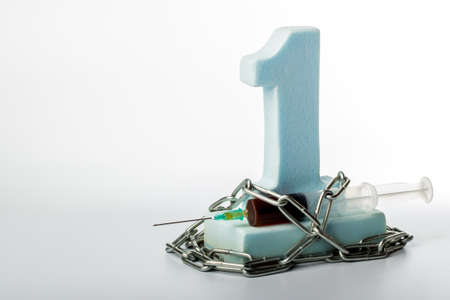 figure one and syringe wrapped with chain
