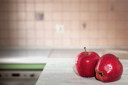 red apples with water drops on a white table in the kitchenの写真素材