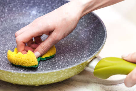 Hand wash dirty pans of food stains on light backgroundの写真素材