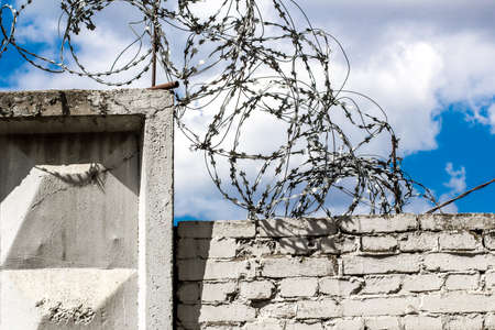 metal barbed wire on top of concrete fence