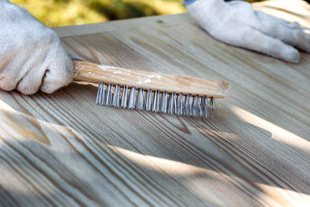 metal brush in hand on a wooden backgroundの写真素材