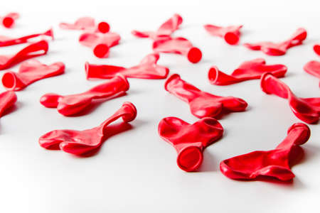 not inflated balloons in the shape of hearts scattered on a white background