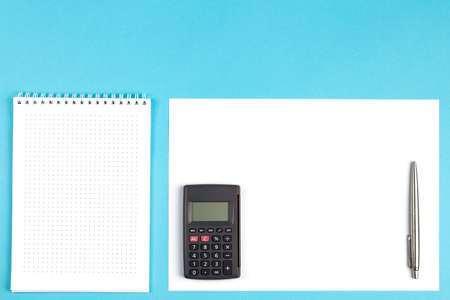 workspace top view. office Desk with office supplies and calculator. top view blue background