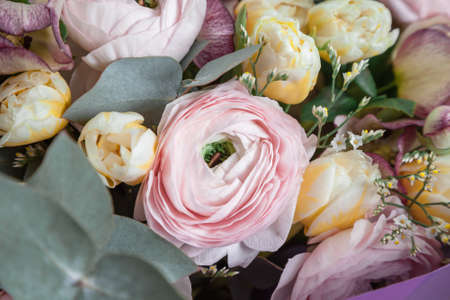 flowers in bouquet close-up. pink Ranunculus and yellow tulips, eucalyptus leaves