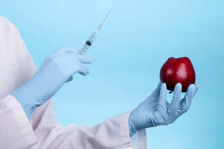 Closeup needle injected into red apple, Genetically engineered food conceptの写真素材