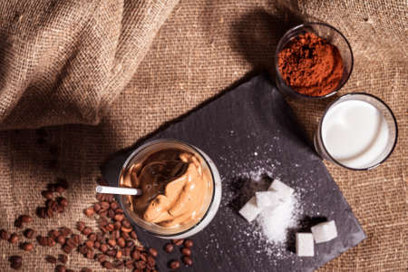 Cold trendy drink Korean dalgon iced coffee on a dark background. delicious and popular coffee in the trendの写真素材