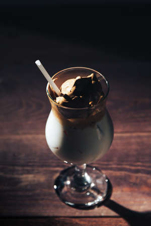 Iced korean Dalgona Coffee, a trendy fluffy creamy whipped coffee with a white tube and ice. trendy coffee drinkの写真素材