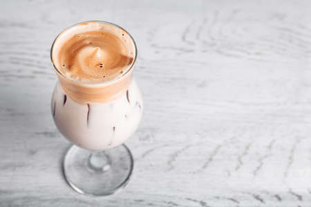 Iced korean Dalgona Coffee, a trendy fluffy creamy whipped coffee with a white tube and ice. trendy coffee drinkの写真素材