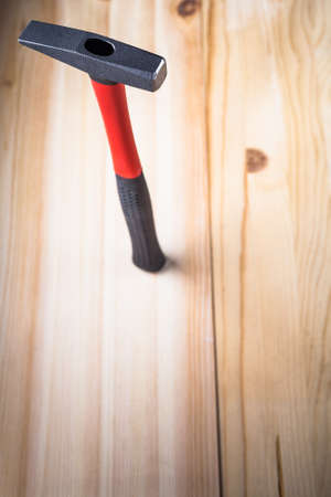 quality hammer stands on a wooden table beautiful advertising hammer. focus on the iron hammer....