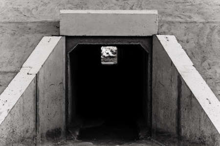 Large rectangular tunnel for water passage under railway tracks. The view from the outside. Black and white photo.の写真素材
