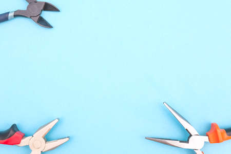 Tools worker, various pliers on a blue background, top view with free space