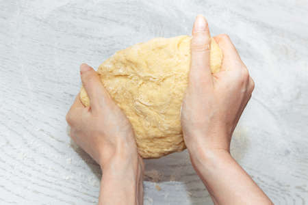 girl is holding a raw dough for buns. concept of home cooking. making homemade doughの写真素材
