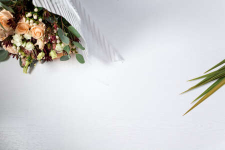 flowers and leaves on light white wooden background. blank for textの写真素材