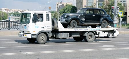 Tow truck transports an old car on the streets of Moscowのeditorial素材
