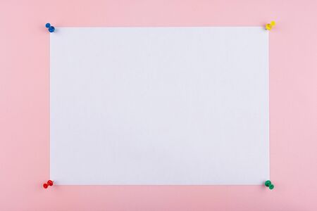 white sheet fastened with clerical multi-colored buttons on a pink backgroundの写真素材
