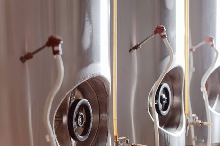 Brewery, beer tanks, cylinder-conical fermentation tanks backlit