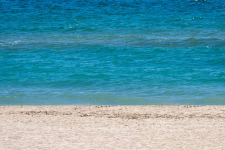 beach coastline, yellow sand, azure sea with small wavesの写真素材
