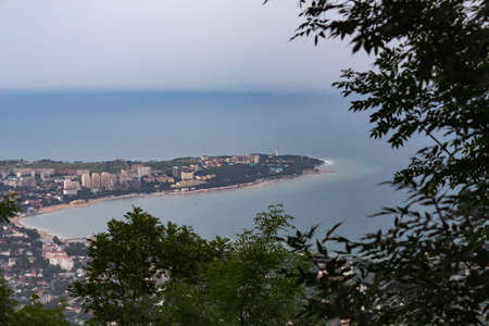 part of the city with a lighthouse, frame through vegetation, against the backdrop of the beginning...