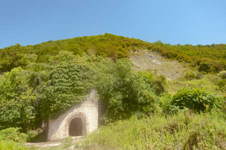 The old loophole fortress of the big cobblestones in the green thickets, used as a background