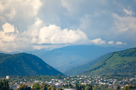 City in a mountainous hollow against the cloud sky with blurry background, used as a background or texture, soft focusの写真素材