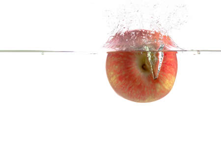 ripe red apple and clear water splash isolated on whiteの写真素材
