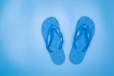 Blue rubber flip-flops isolated over blue background, pair of thongs, shot aboveの写真素材