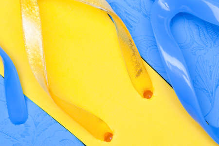blue and yellow rubber beach flip flops close-up, used as a background