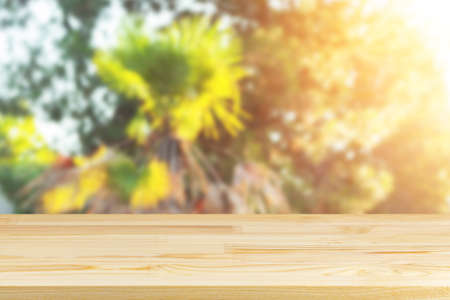 wood table top on blur tropical palms and sunlight background