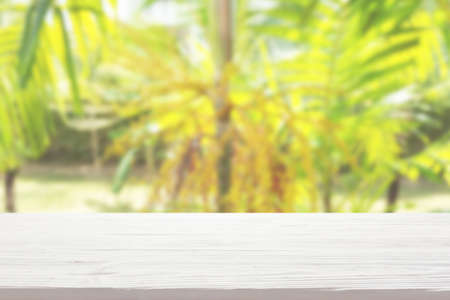 white wood table top on blur tropical plants background