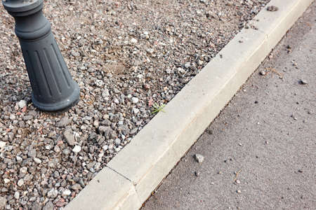 the curb of the pavement with rubble, the street lamp, not finishedの写真素材