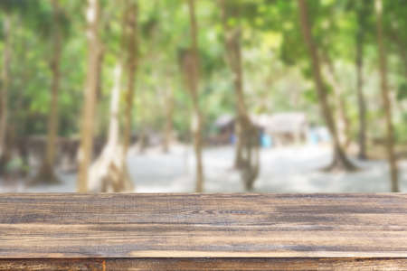 wood table top on blur beach and palm trees background