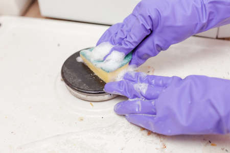 female hand in a glove washes the stoveの写真素材