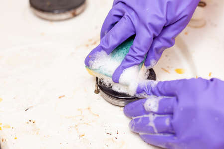 female hand in a glove washes the stoveの写真素材