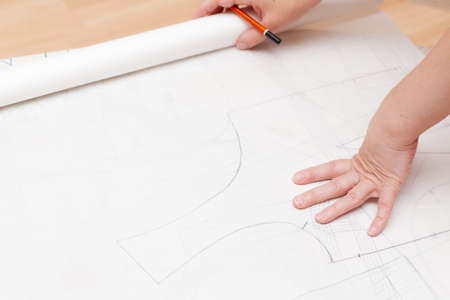 Female designer drawing flat paper patterns. Exclusive clothes making concept.