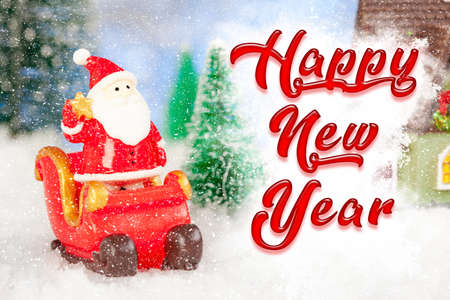 Happy New Year greeting card. Toy santa claus and sleigh in the snow, artificial fir trees around