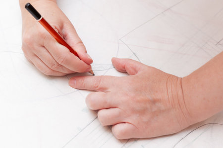 Female designer drawing flat paper patterns. Exclusive clothes making concept.の写真素材