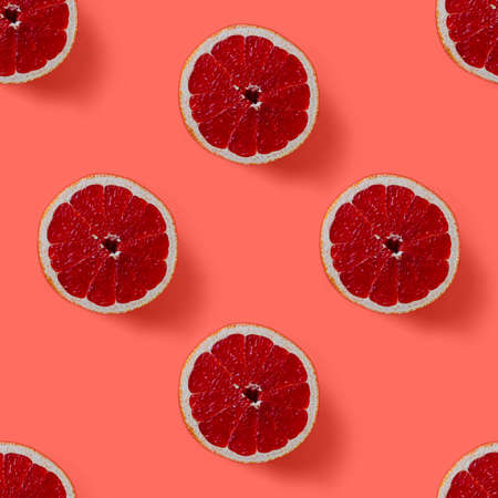 seamless pattern consisting of halved grapefruit on the background color of living coralの写真素材