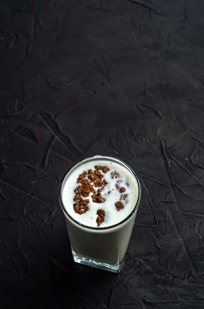 Chocolate cookies biscuit dipped with a glass of milk on dark backgroundの写真素材