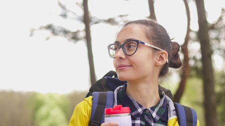 Portrait of young travel woman holding bottle of hot drink. Travel and hiking conceptの写真素材